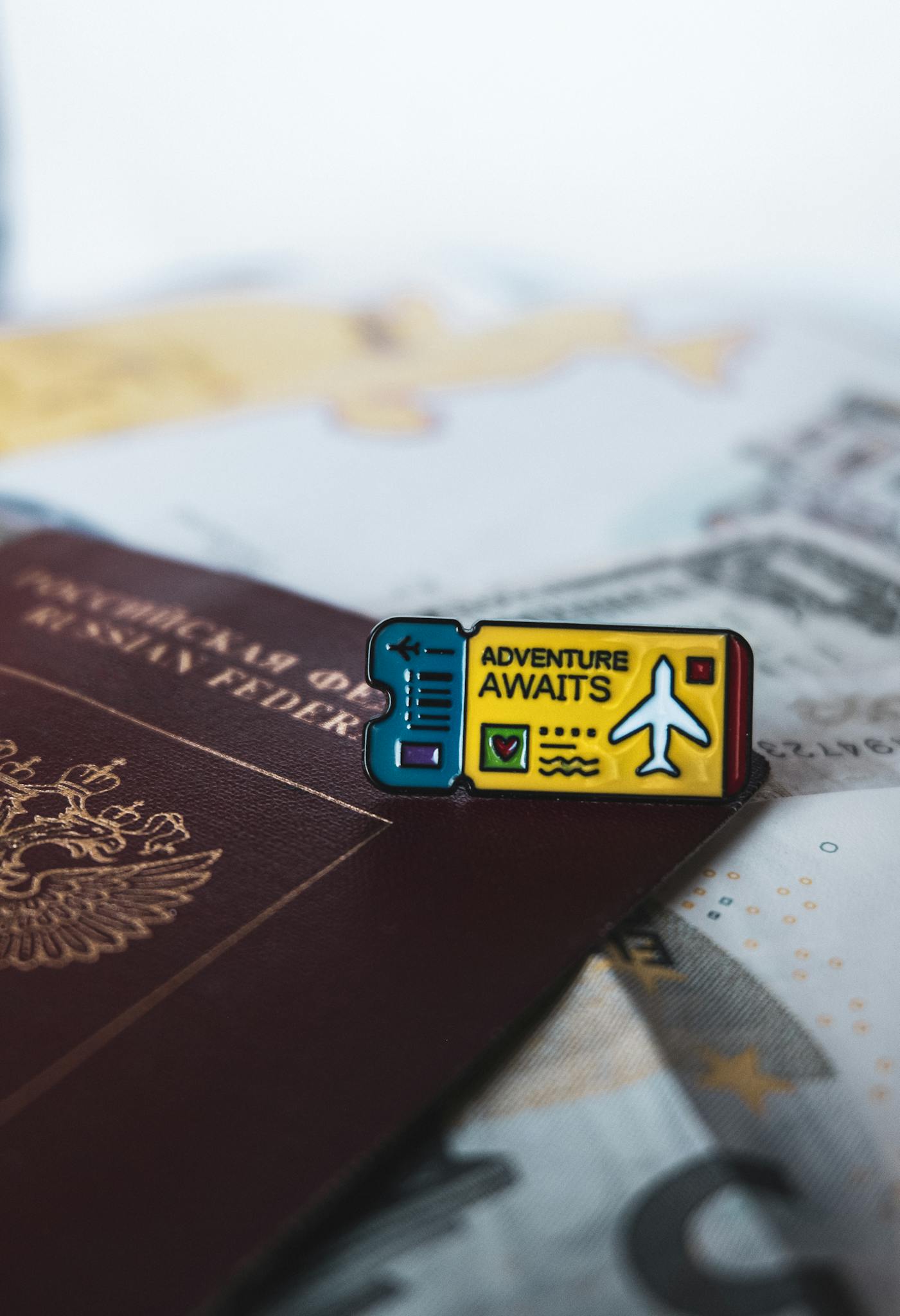 A Russian passport with an 'Adventure Awaits' pin symbolizes travel and exploration.